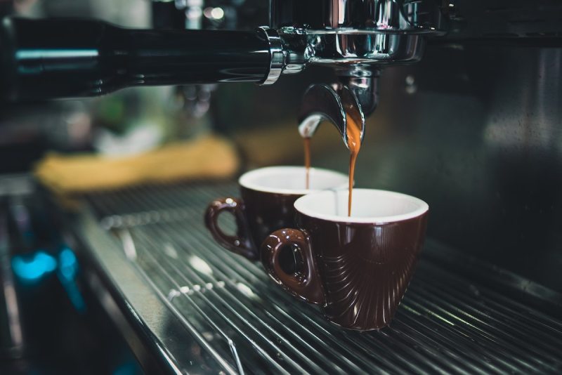 Two cups of coffee being made at a shop